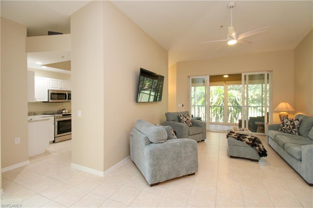 Tiled living room featuring vaulted ceiling and ceiling fan
