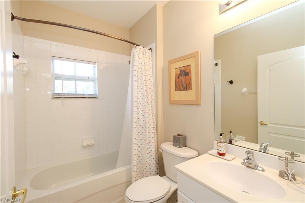 Full bathroom featuring vanity, toilet, and shower / bathtub combination with curtain