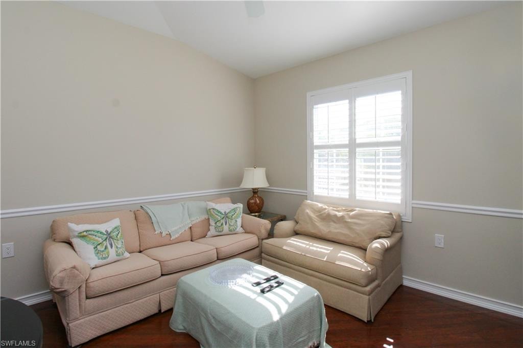 Living room with dark hardwood / wood-style floors and vaulted ceiling