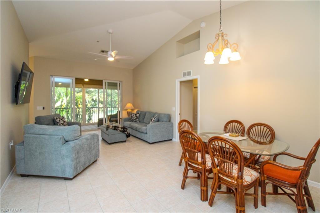 Dining room featuring ceiling fan with notable chandelier and high vaulted ceiling