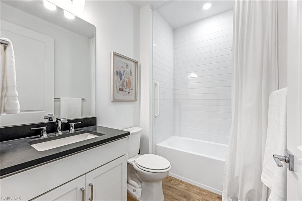 Bathroom with vanity, light wood-type flooring, and shower / tub combo