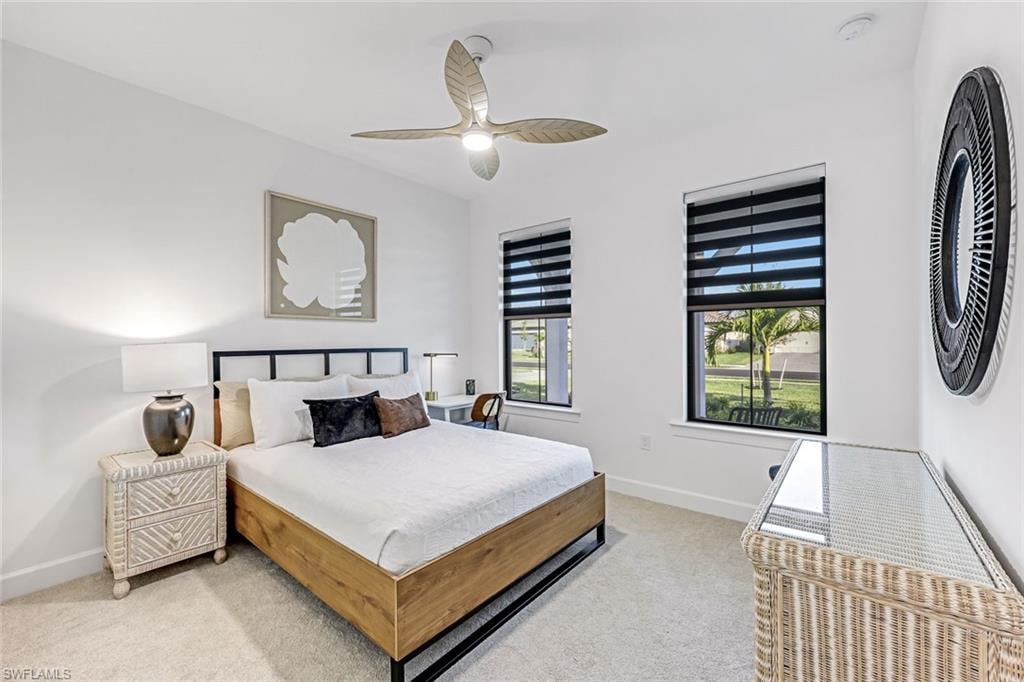 Bedroom with light carpet and a ceiling fan