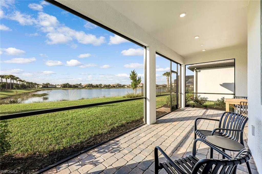 Sunroom with a water view and recessed lighting