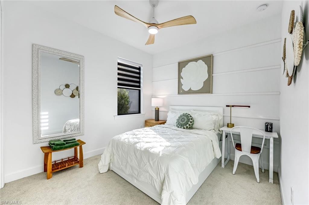 Carpeted bedroom with ceiling fan and baseboards