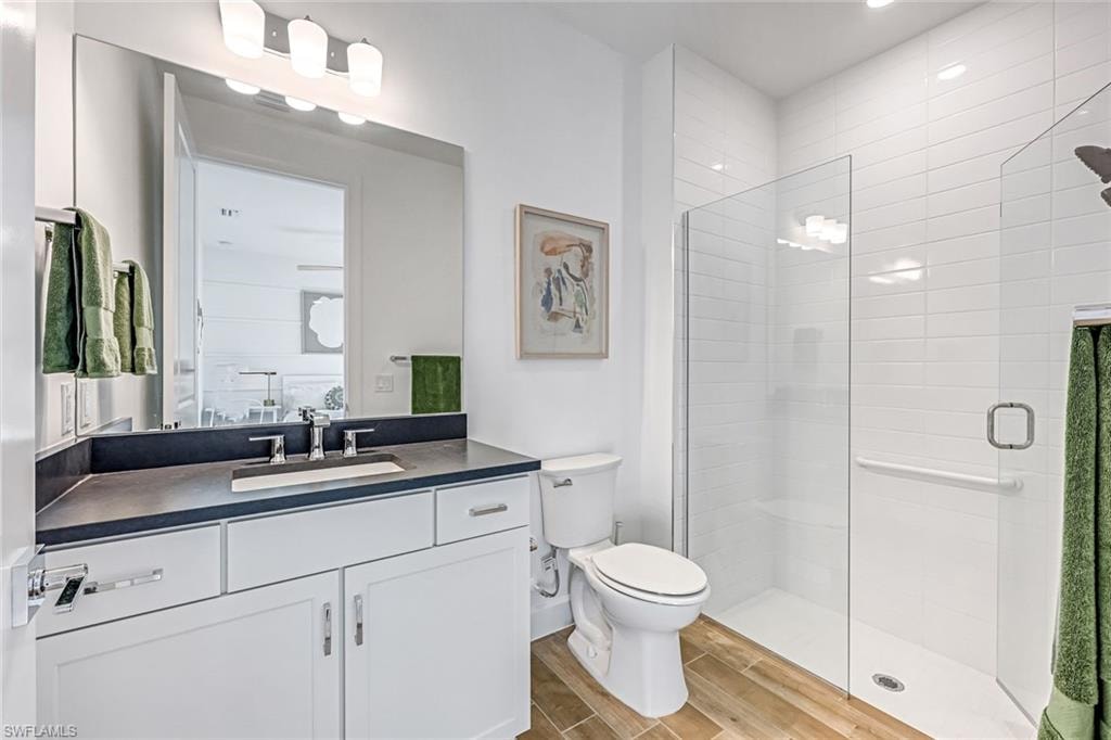 Full bathroom featuring vanity, a stall shower, and wood tiled floors