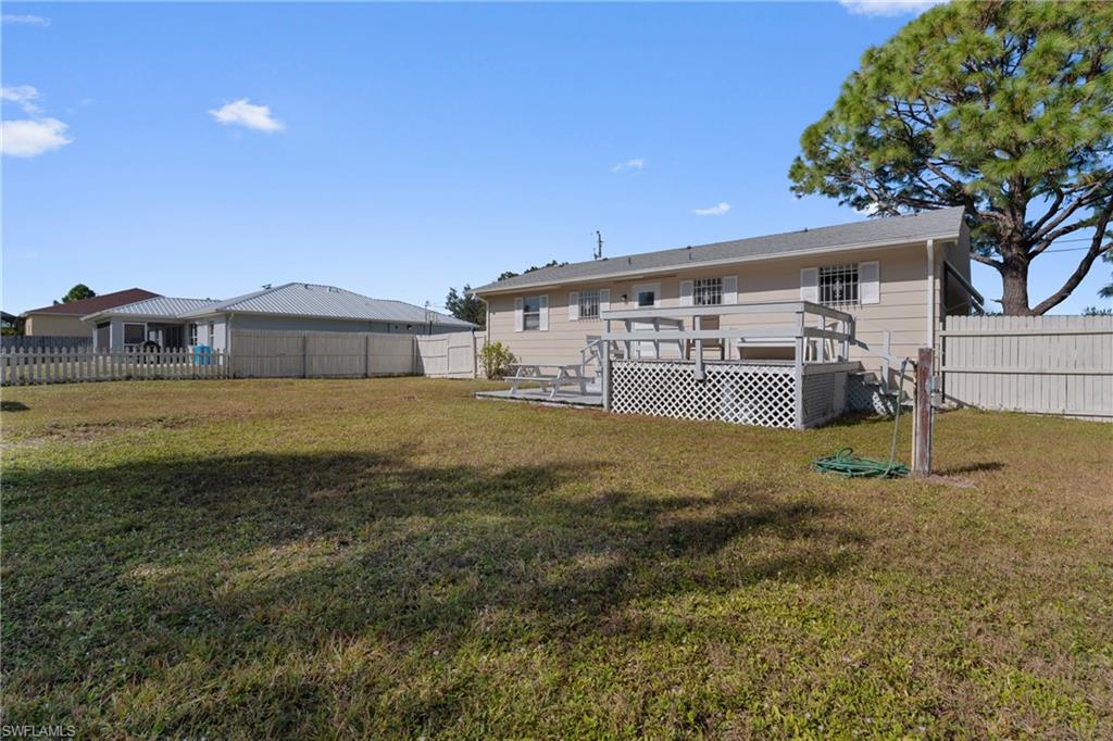 Rear view of house with a deck and a fenced backyard