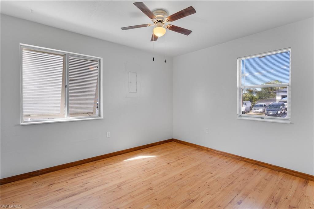 Spare room featuring light wood-style floors, electric panel, and ceiling fan