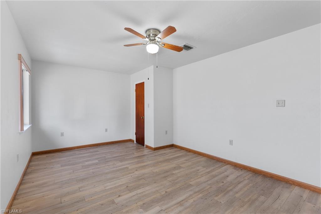 Empty room with light wood finished floors and ceiling fan