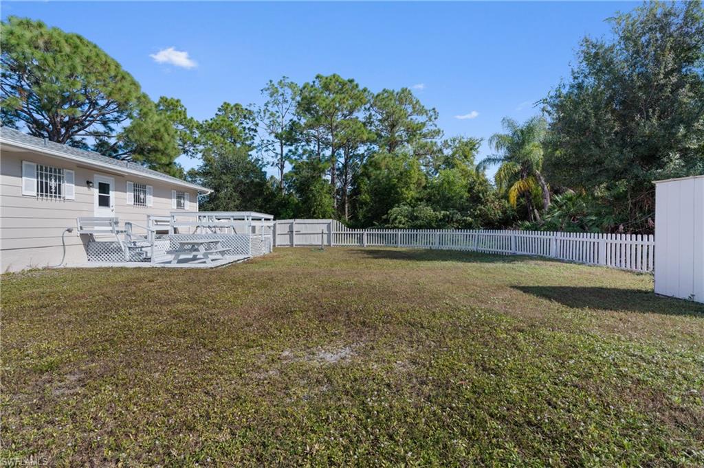 Fenced backyard with a patio and view of scattered trees