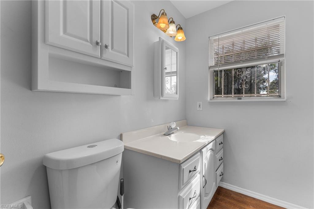 Half bathroom with vanity and dark wood finished floors