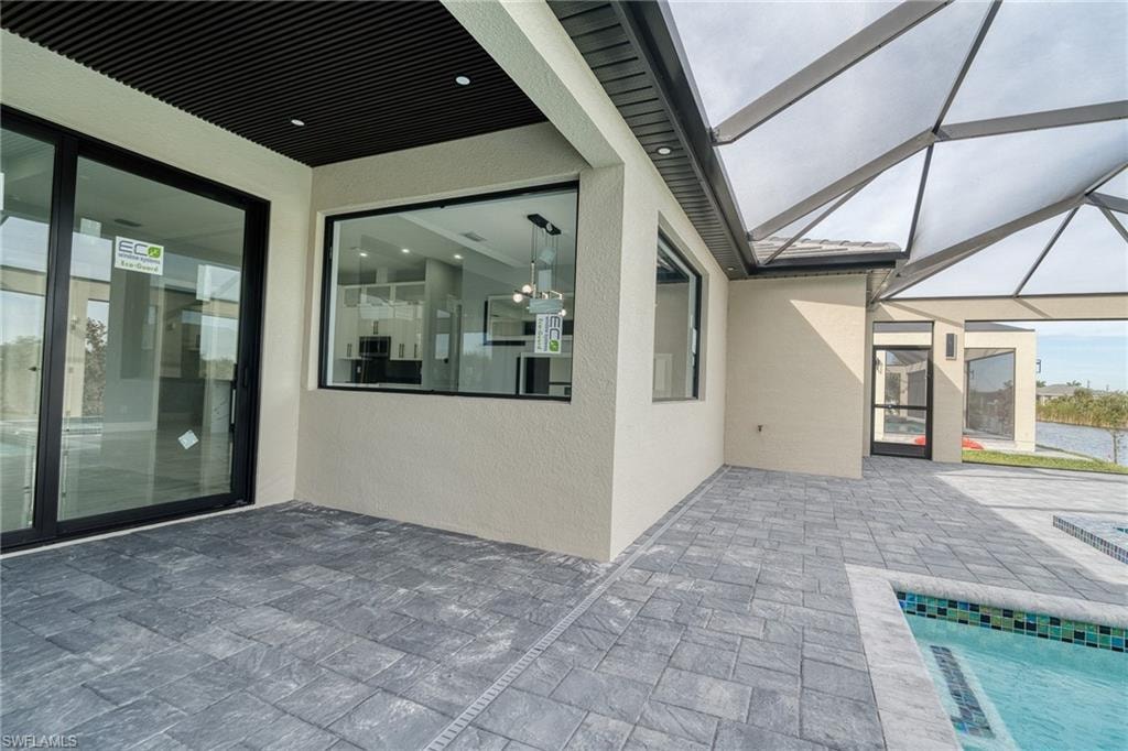View of patio with a sunroom, an outdoor pool, and a lanai