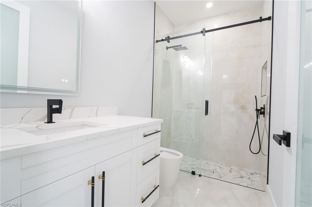 Full bath featuring a shower stall and vanity