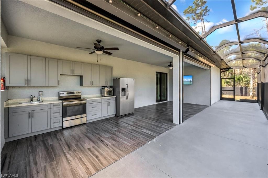 Kitchen with light countertops, gray cabinetry, stainless steel appliances, ceiling fan, and a barrel ceiling