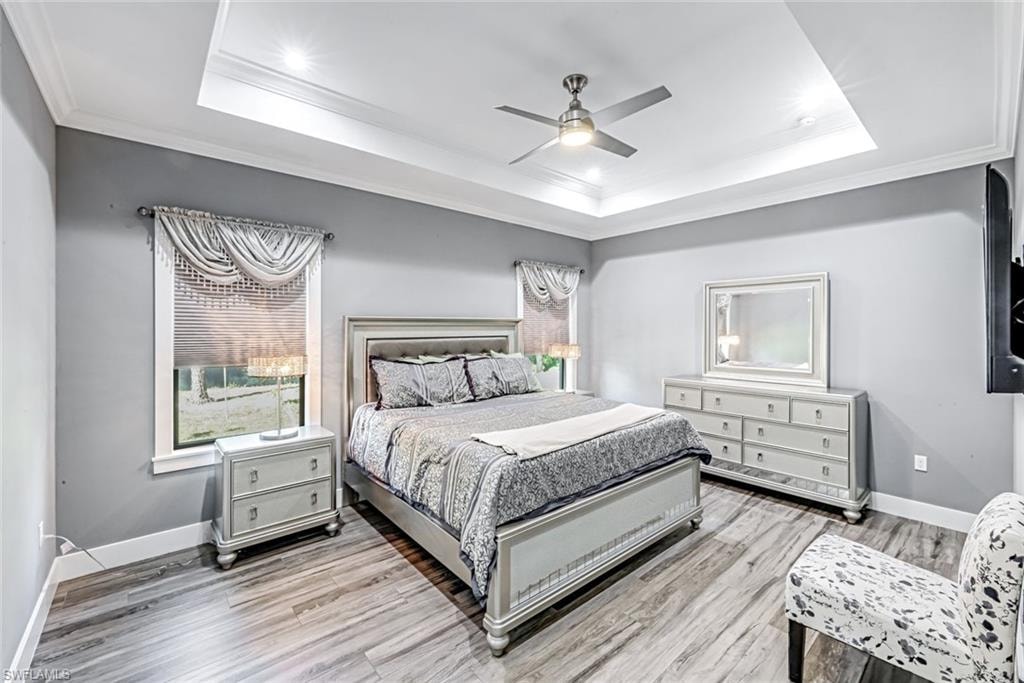 Bedroom with ornamental molding, ceiling fan, and light wood finished floors