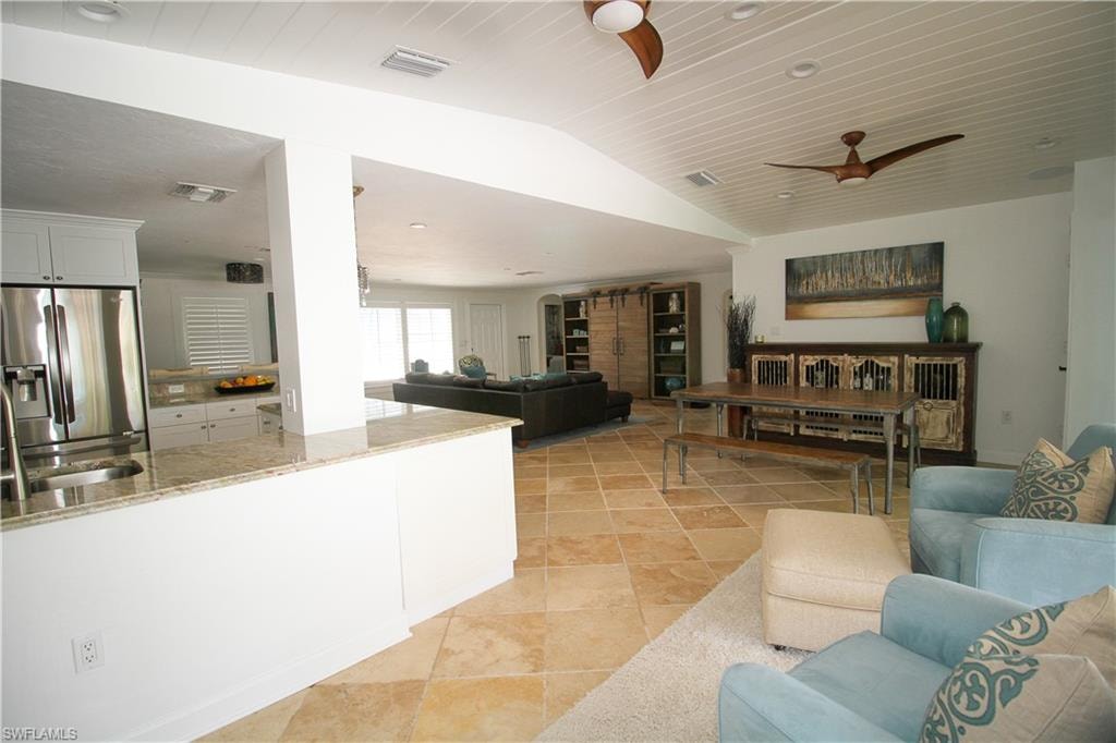 Living room with ceiling fan and lofted ceiling