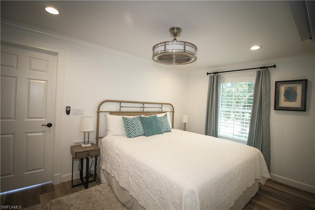 Bedroom with ornamental molding, recessed lighting, and dark wood-style flooring
