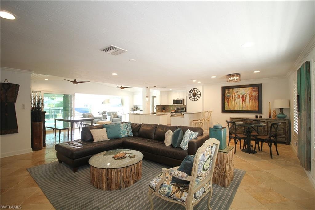 Living room with crown molding, healthy amount of natural light, recessed lighting, and ceiling fan