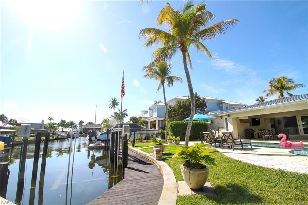 Dock area with an outdoor pool, a water view, a patio area, and boat lift