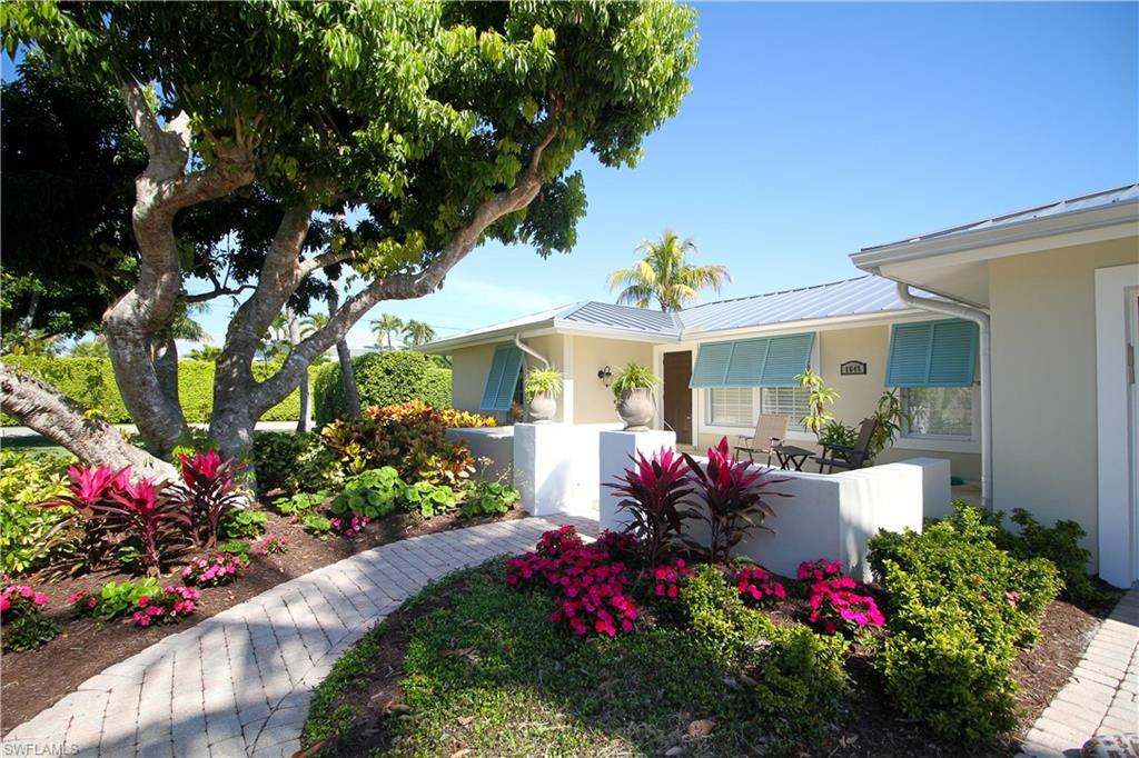 View of property exterior featuring a fenced front yard, stucco siding, and a metal roof
