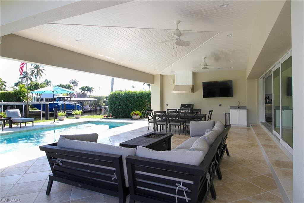 View of patio featuring an outdoor living space with a fire pit, outdoor dining area, and a ceiling fan