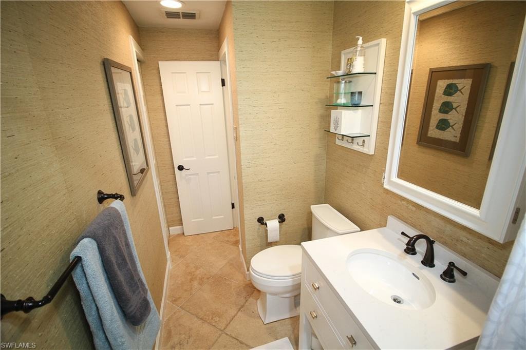 Half bathroom featuring vanity and toilet
