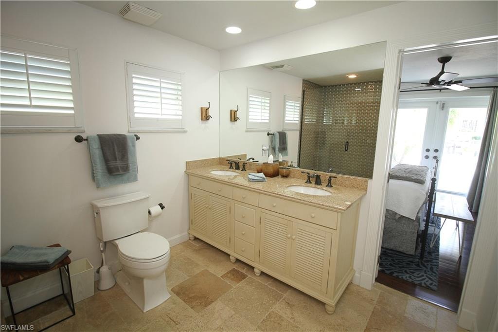 Bathroom featuring connected bathroom, double vanity, plenty of natural light, a ceiling fan, and recessed lighting