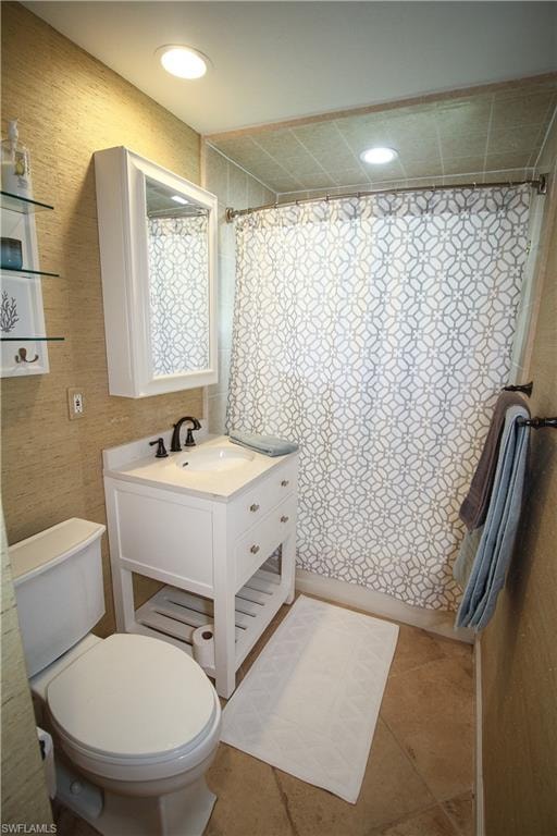 Full bath featuring a shower with curtain, vanity, and light tile patterned flooring