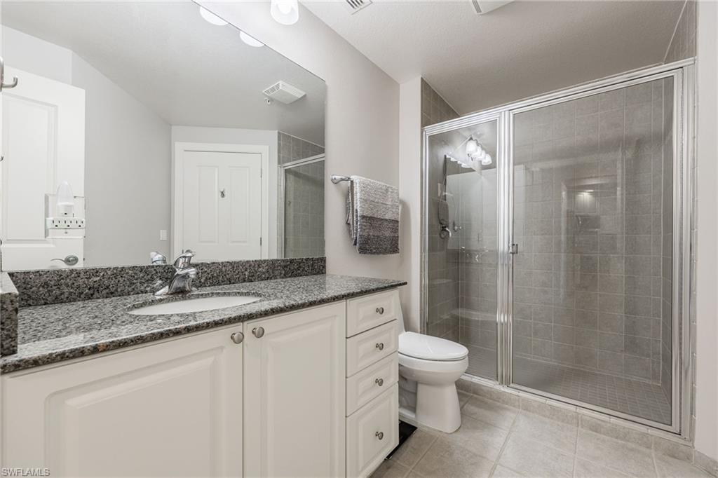 Full bath with vanity, a stall shower, and light tile patterned flooring