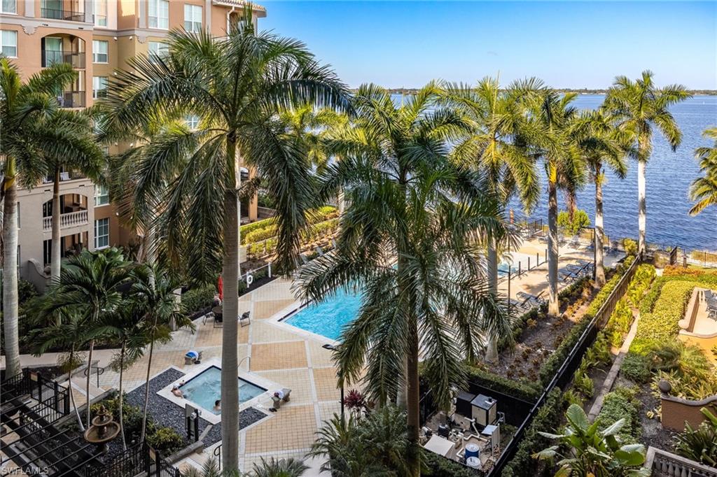 Community pool featuring a water view, a patio area, and a community hot tub