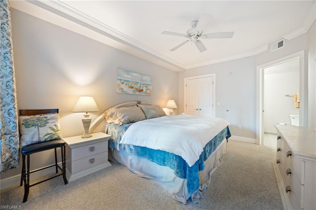 Bedroom with a closet, light colored carpet, crown molding, and ceiling fan