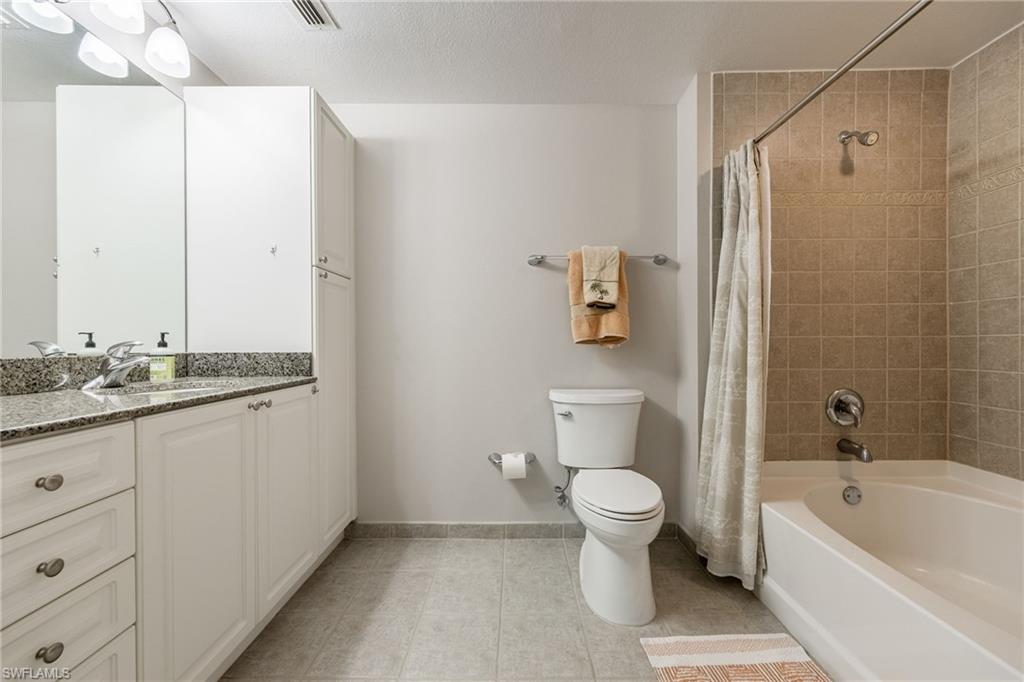 Bathroom with vanity, shower / bath combo with shower curtain, and light tile patterned floors