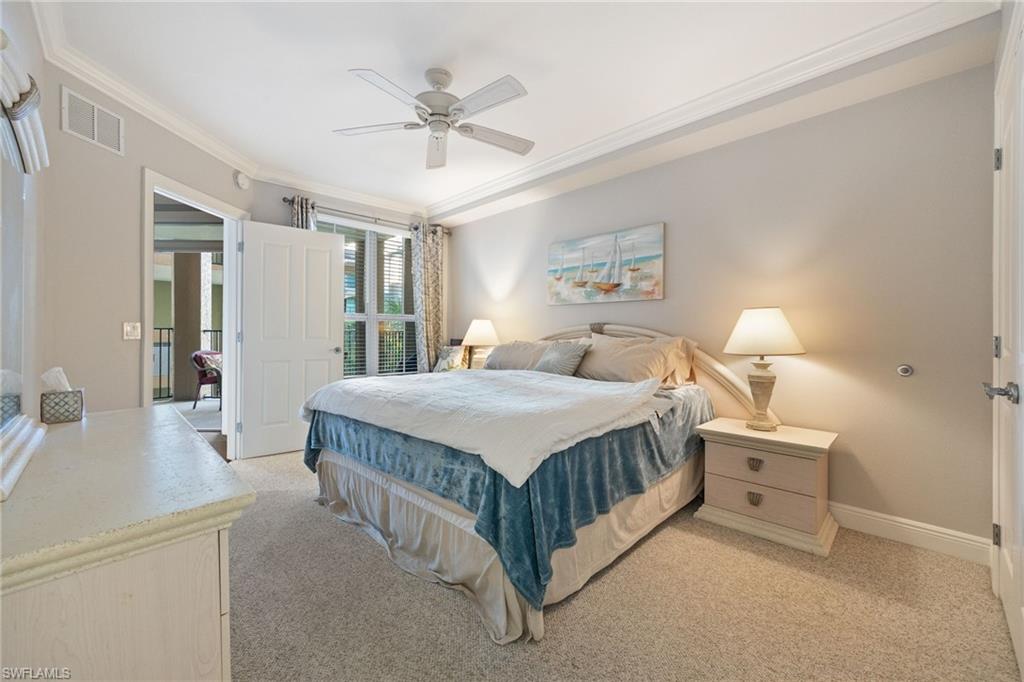 Bedroom featuring light colored carpet, ornamental molding, and a ceiling fan
