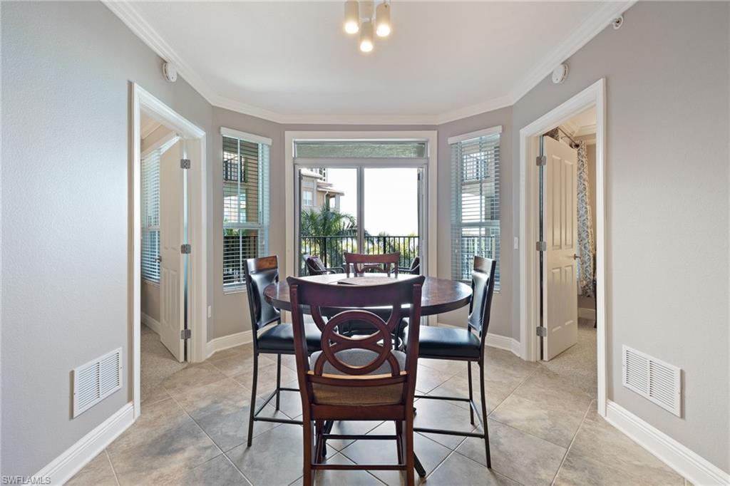 Dining space with ornamental molding and light tile patterned flooring