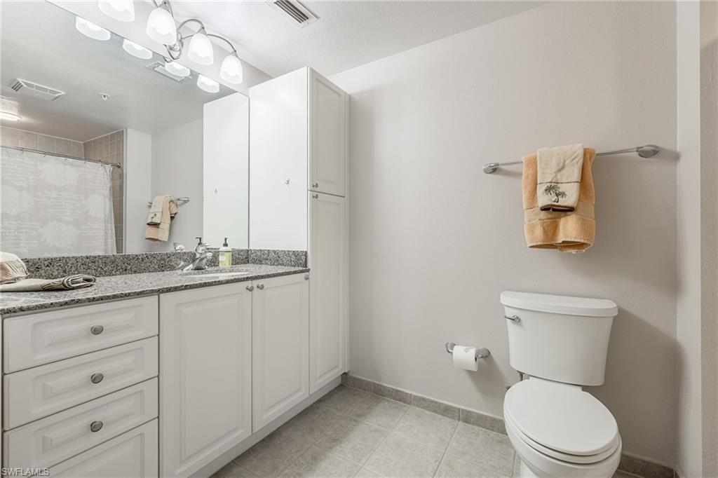 Bathroom with vanity, a shower with curtain, and light tile patterned flooring