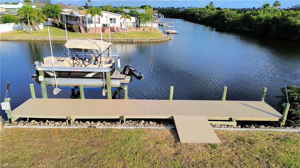 Dock area with a water view, a yard, and boat lift