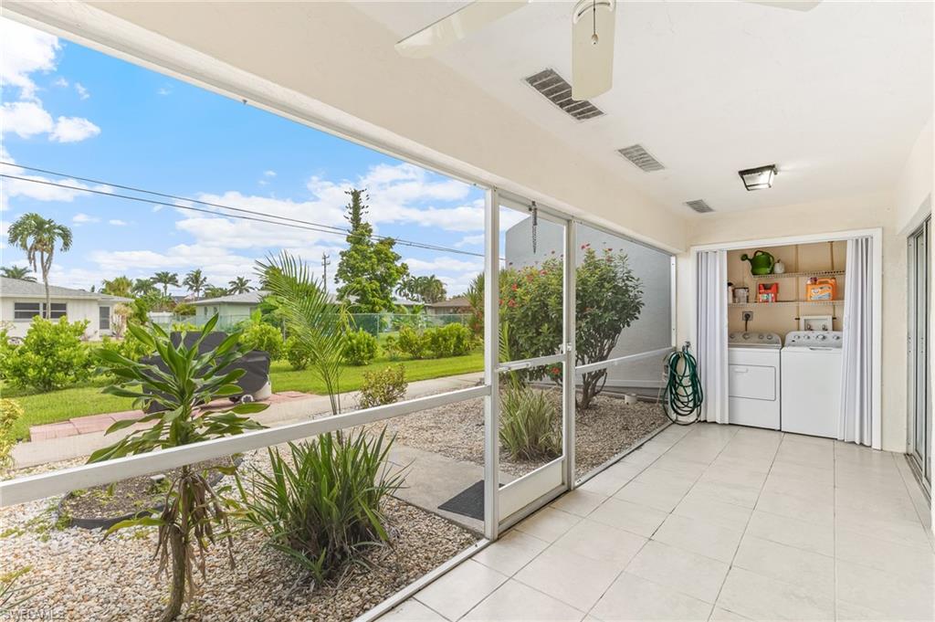 Unfurnished sunroom featuring washer and dryer and tile patterned flooring