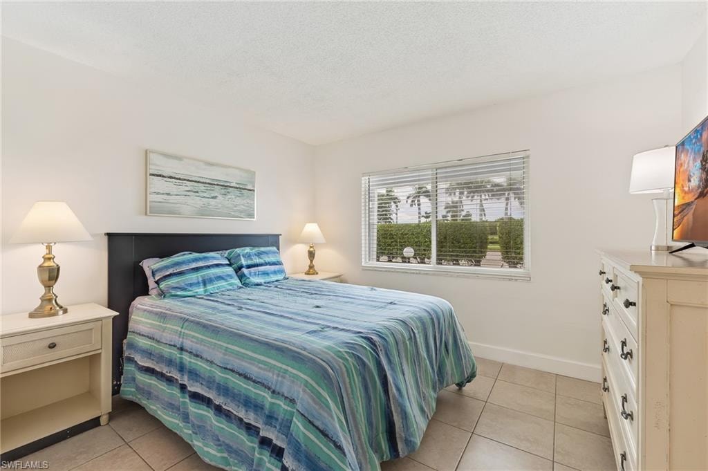 Bedroom with light tile patterned floors and a textured ceiling