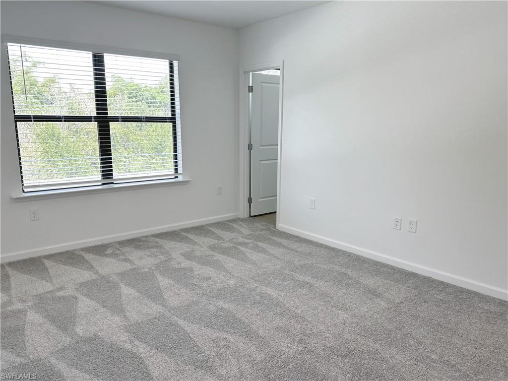 Carpeted empty room with baseboards