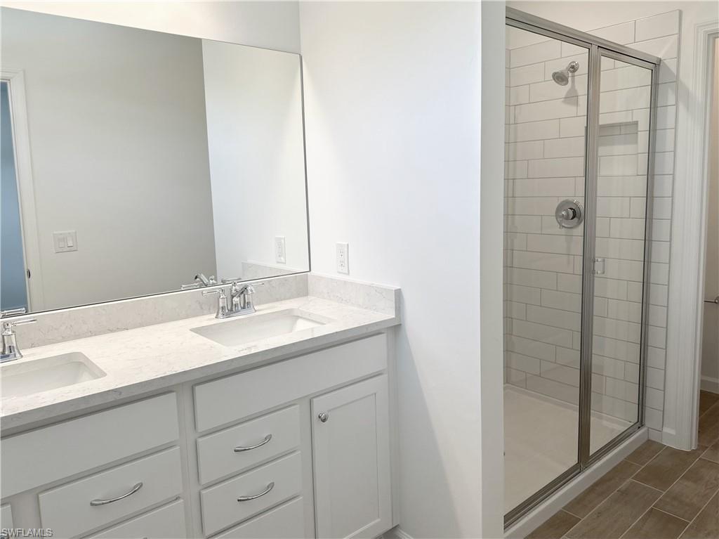 Full bath featuring a shower stall and wood finish floors