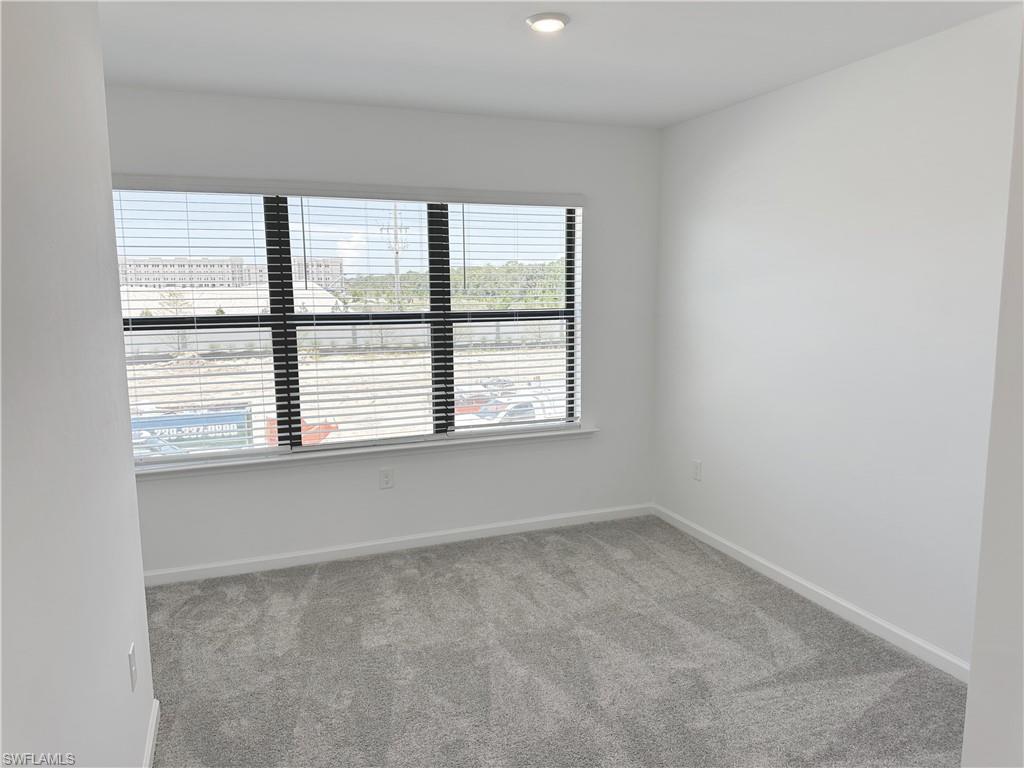 Spare room featuring light carpet and baseboards