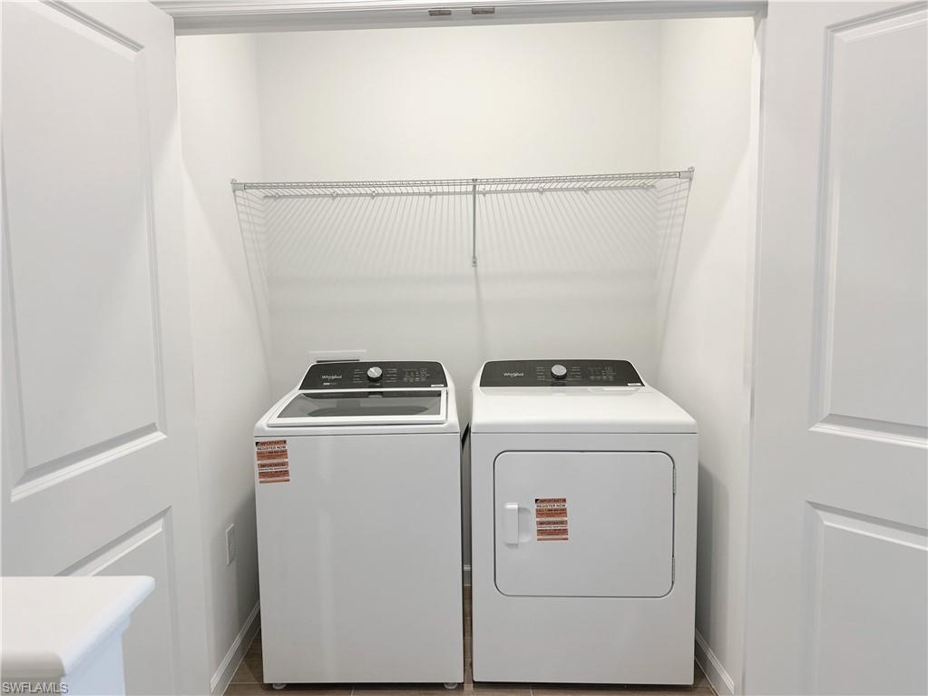 Washroom with washer and clothes dryer and baseboards