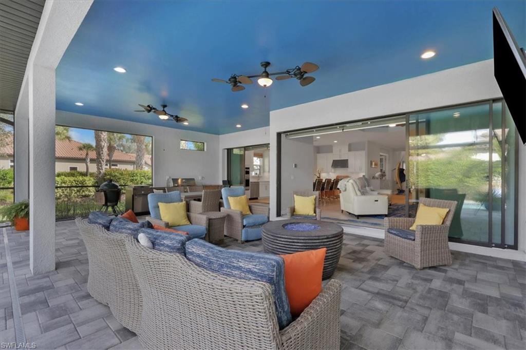 View of patio with an outdoor living space with a fire pit, ceiling fan, and a grill