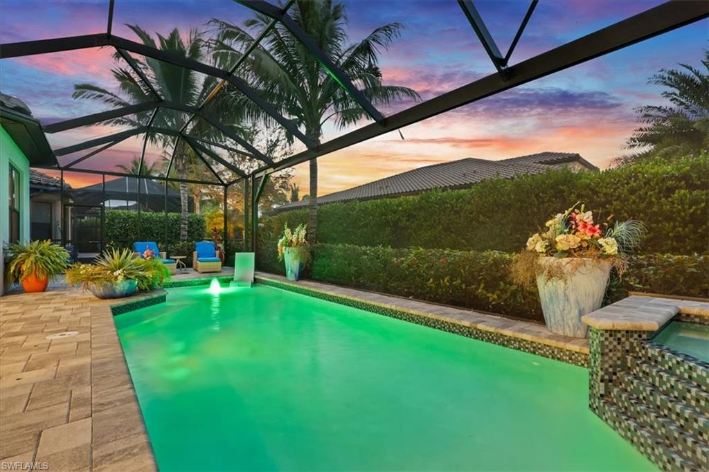 Pool at dusk with a lanai, a patio, and a sunroom