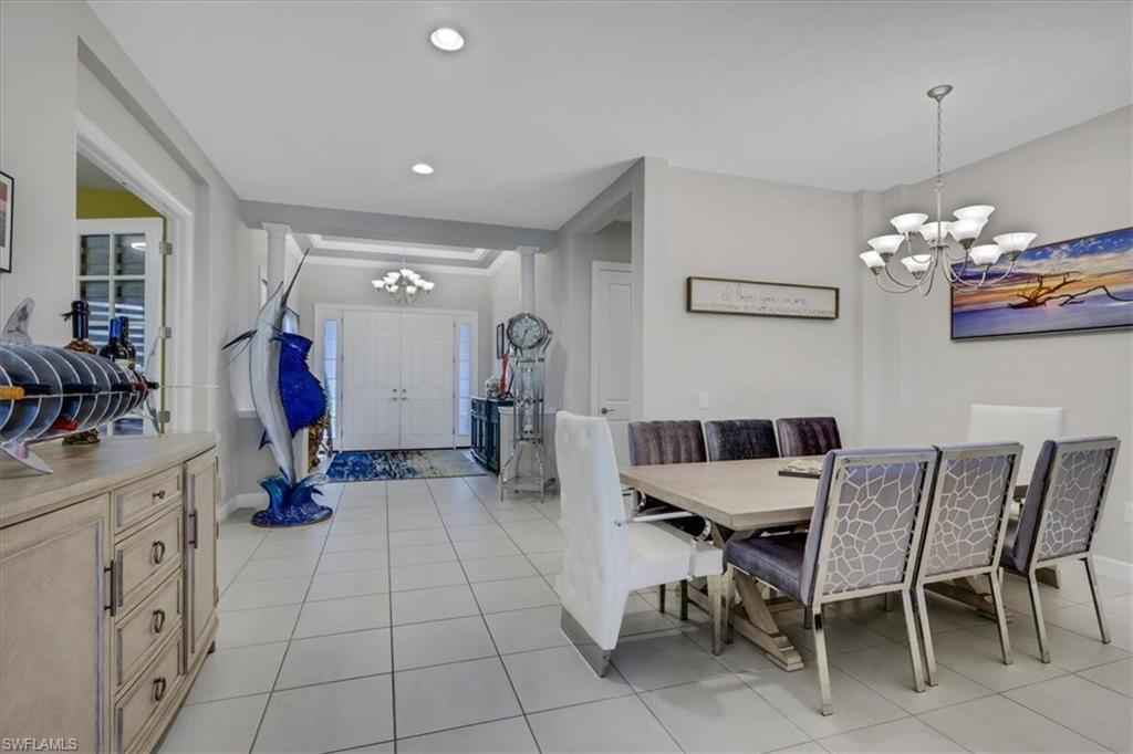 Dining room with a chandelier, light tile patterned floors, and recessed lighting