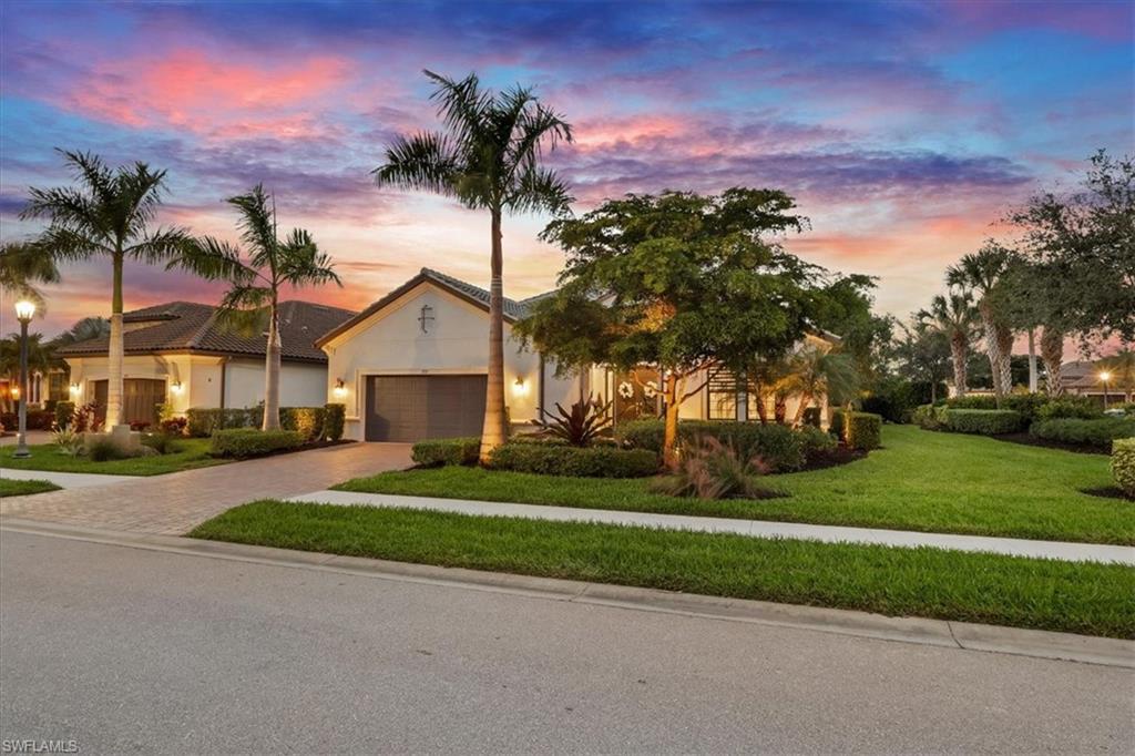 View of front of property with driveway, a lawn, an attached garage, and stucco siding