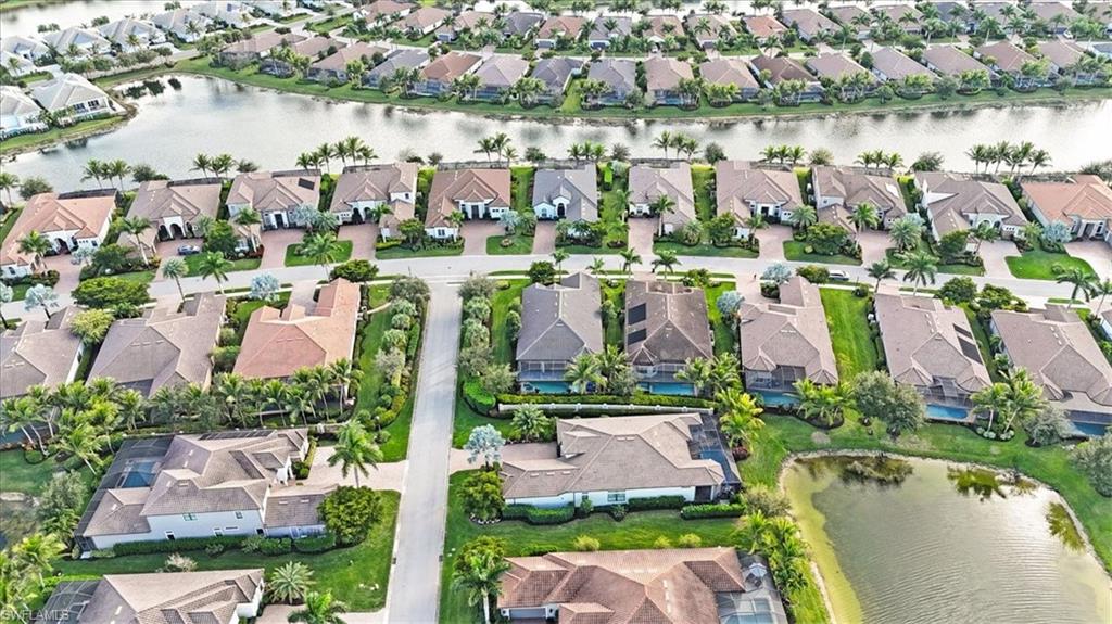 Aerial view of property's location featuring a nearby body of water and nearby suburban area