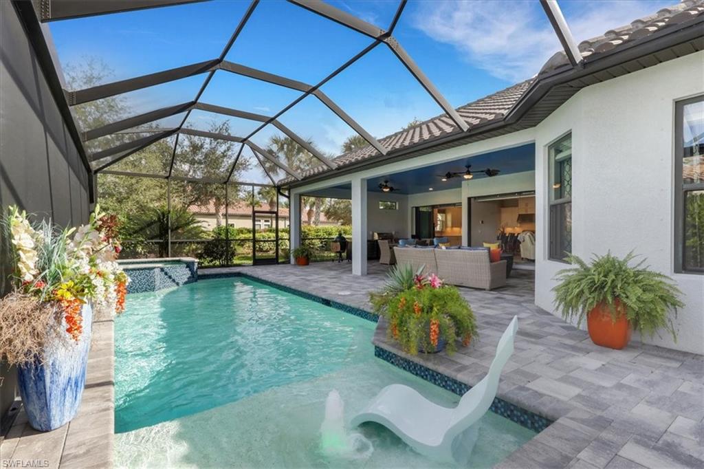 View of pool with an outdoor living space, glass enclosure, a sunroom, a patio, and a pool with connected hot tub