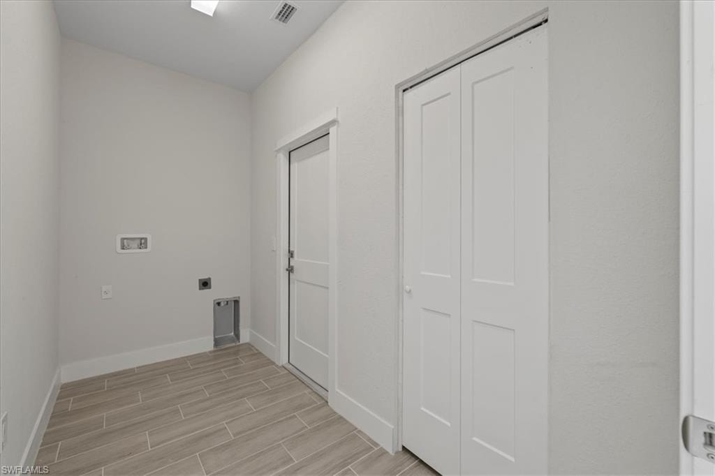 Washroom with wood finish floors, washer hookup, and electric dryer hookup