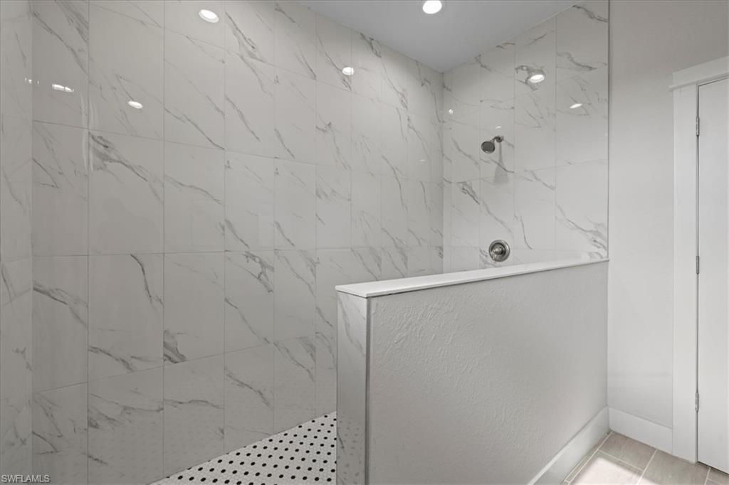 Bathroom featuring a marble finish shower and baseboards