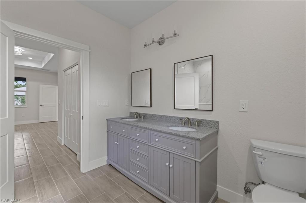 Full bath with double vanity and wood finish floors